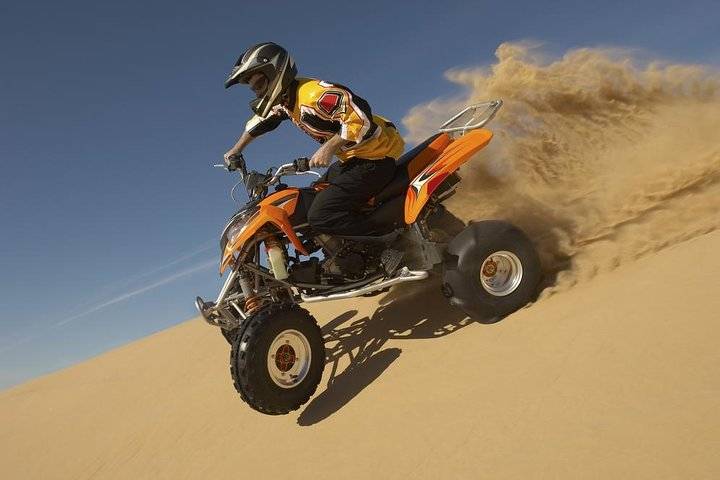Unleash your adventurous spirit in Dubai's vast desert carving through golden sands on a quad bike for an unforgettable off-road journey that captures the essence of exploration.